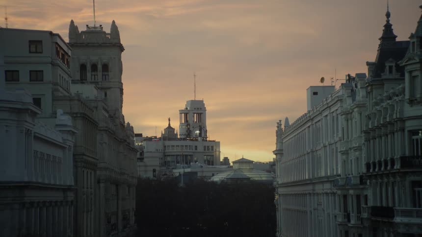 The sun sets behind city buildings