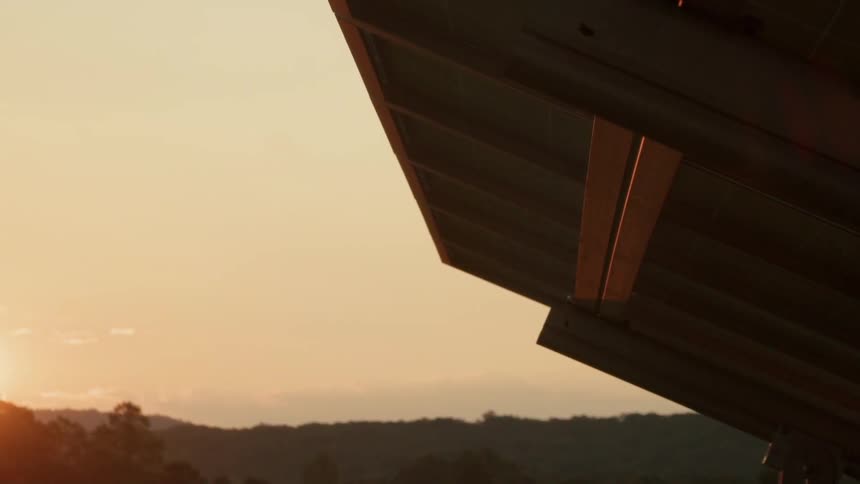 The sun sets behind a solar panel