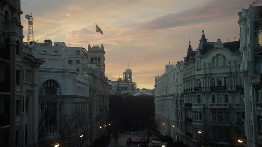 A flag blows in the breeze above a city building