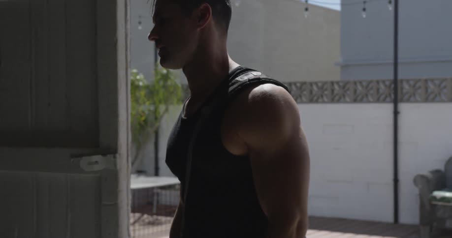 Man opens a sliding door and walks into a large dim room