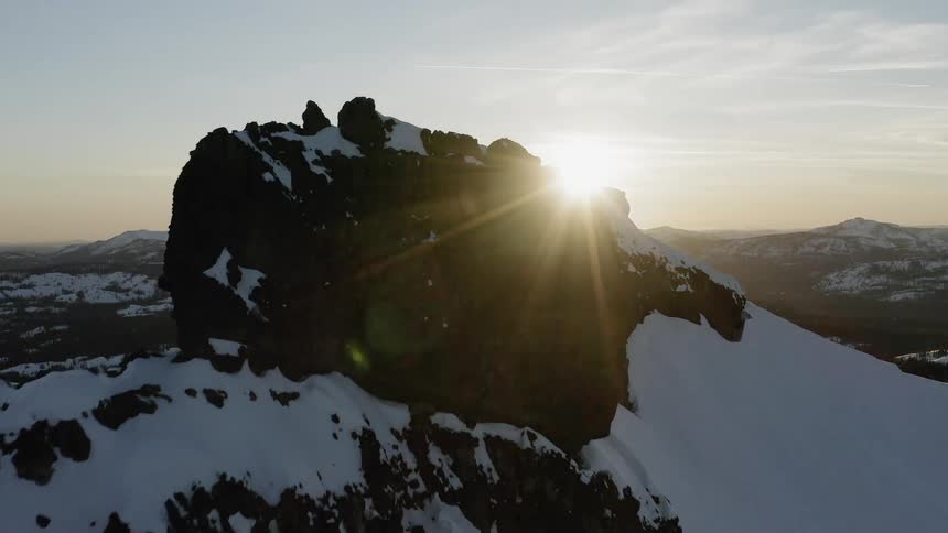 The sun sets over snowy mountains