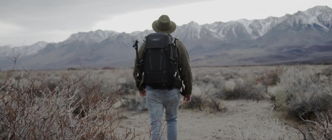Man hikes towards snow-capped mountains
