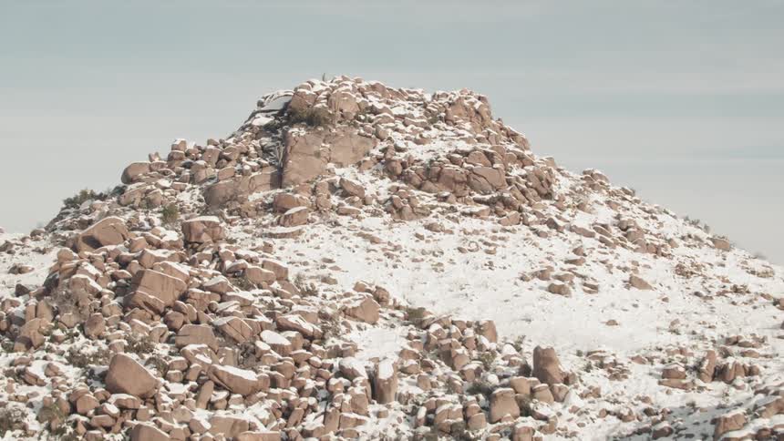 Snow covers a pile of boulders