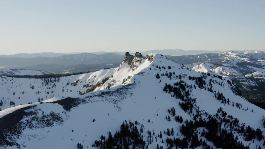 The sun is shining bright on the snow covered mountain