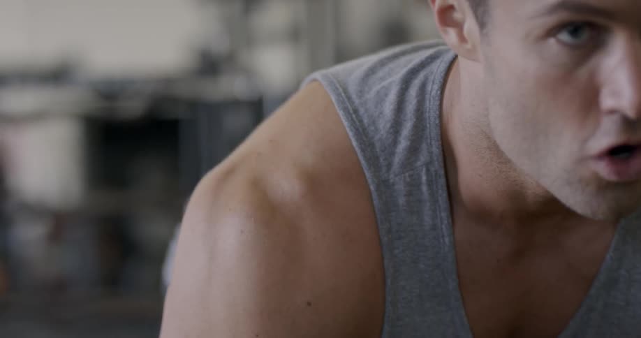 A man sets and lifts a weight at the gym