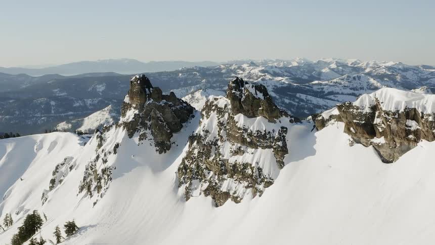 Snow covered rocky peaks and slopes on a sunny day