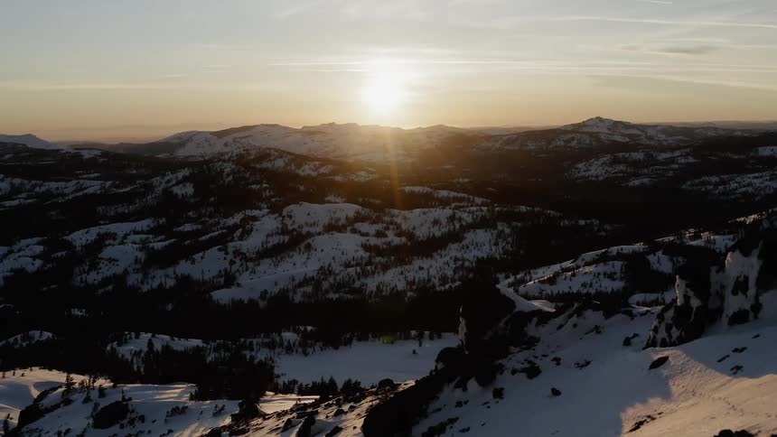 The sun sets over snow covered ridge and valley