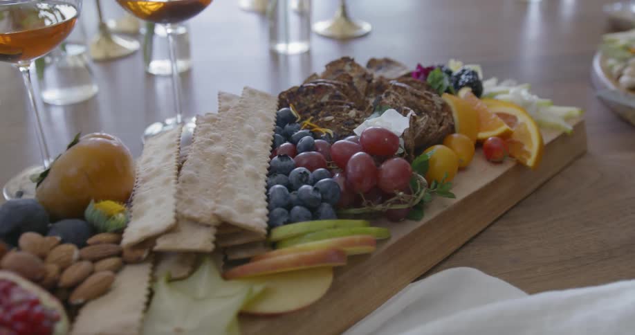 A plate of fruit and snacks sits on a table
