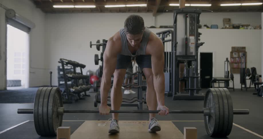A man lifts weights in a gym