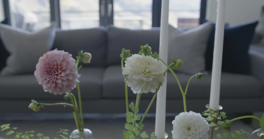 Flowers and candles sit on a coffee table
