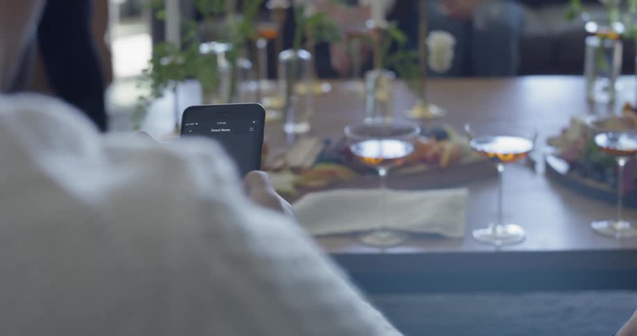 A man is using his cellphone while sitting at a party in daylight