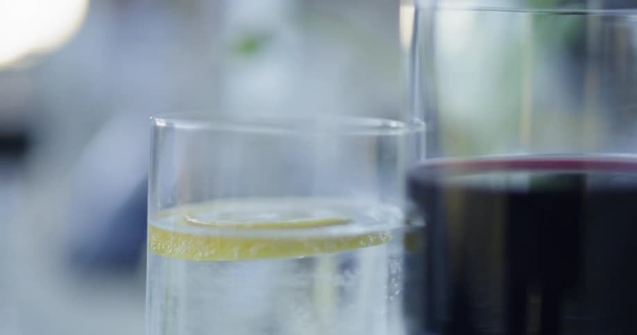 Glasses of wine and tonic water sit on a table