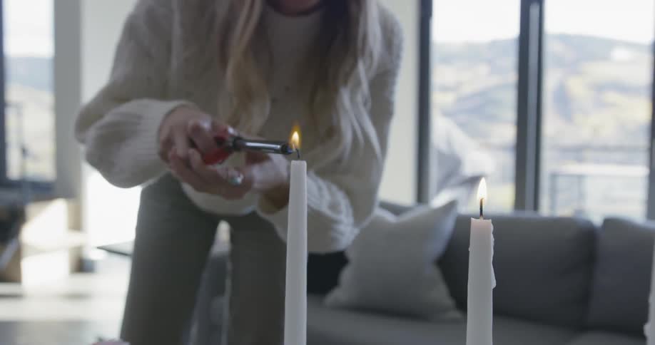 A woman is lighting candles in the room