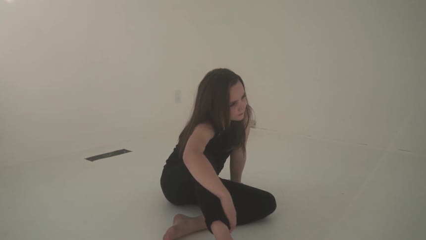 A girl sits in an empty bedroom