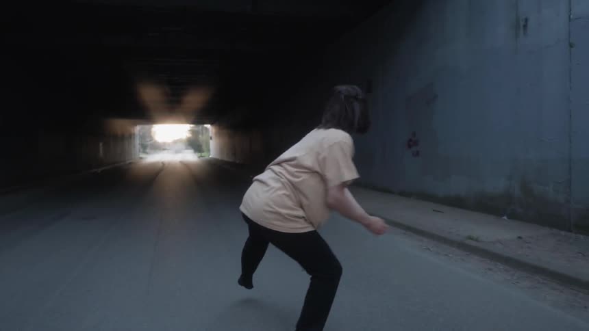 A woman dances in a tunnel