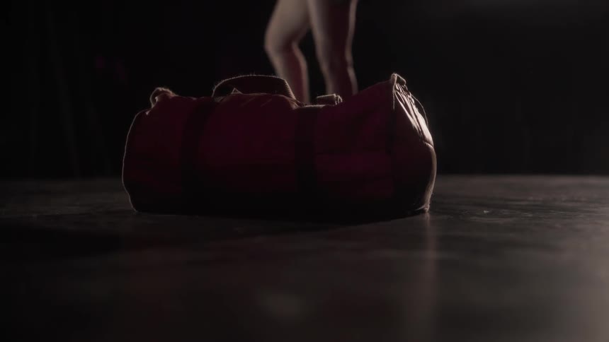 A woman drops a duffel bag on a floor