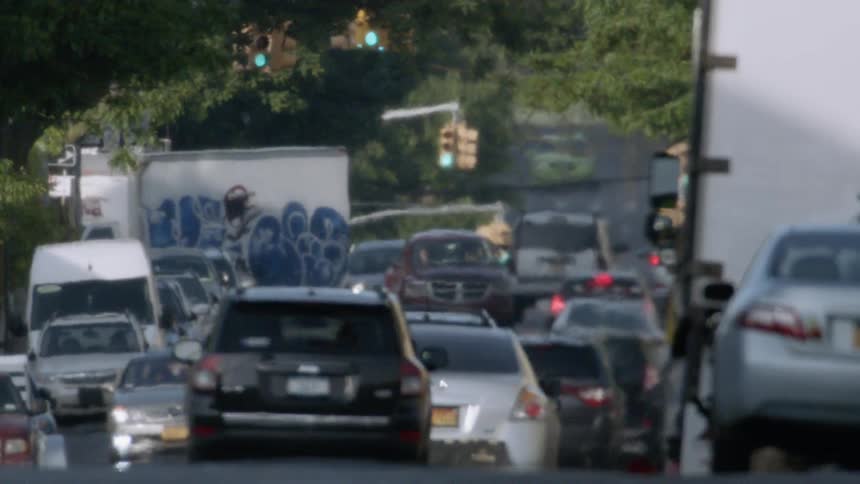 Cars drive on a city street