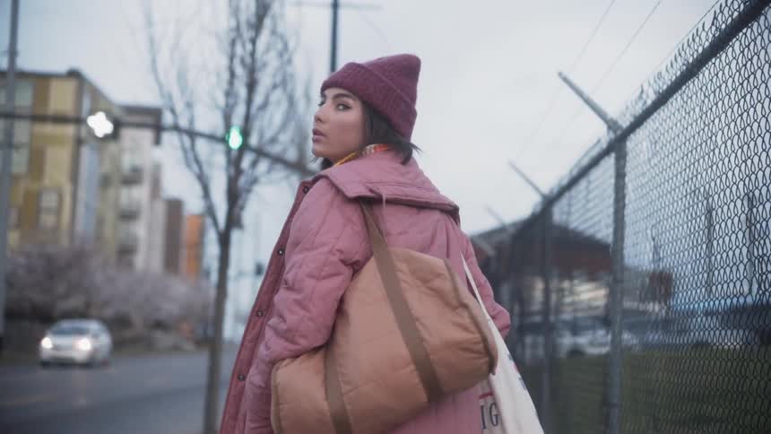 Woman walks on a city sidewalk