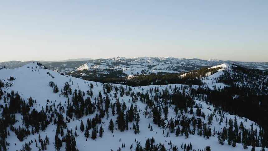 Sunlight is touching the peaks of mountain slopes on a sunny winter day