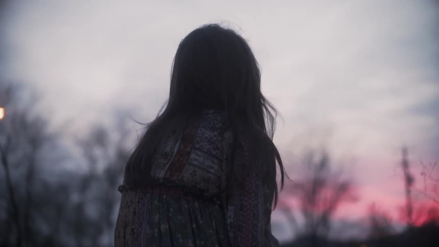 Girl sits outside at sunset
