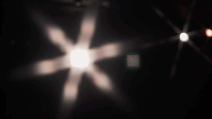 Woman dances beneath spotlights
