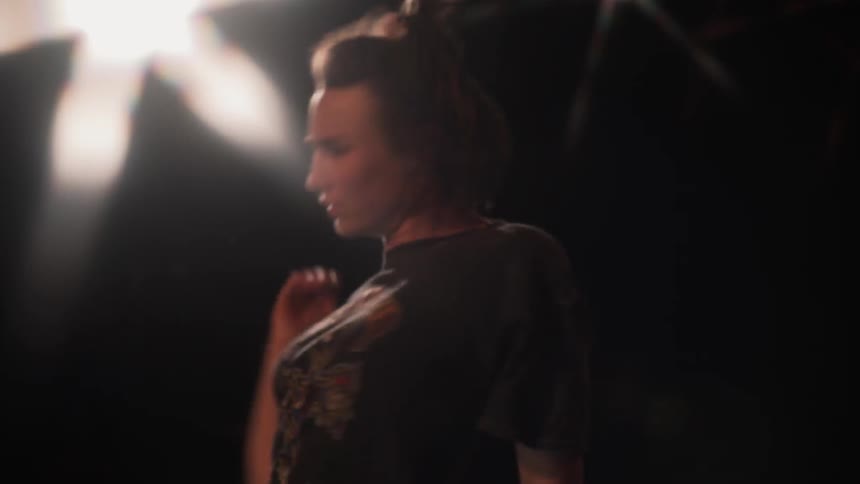 A girl is jerking and flopping as she dances inside in front of a mirror