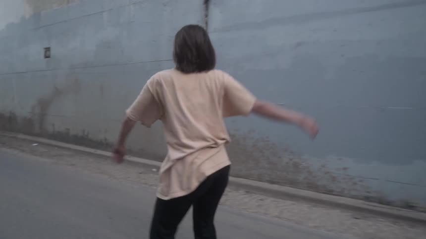 A woman is dancing in the street on a cloudy day