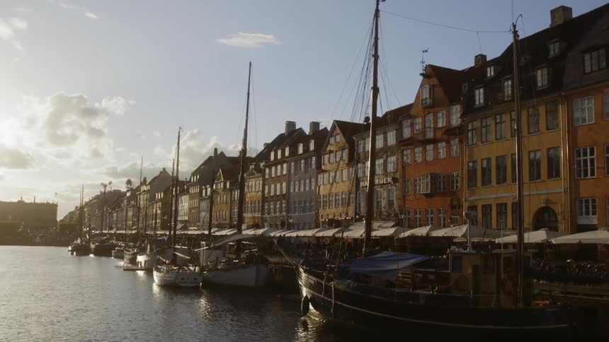 Boats floating in a canal next to a row of buildings