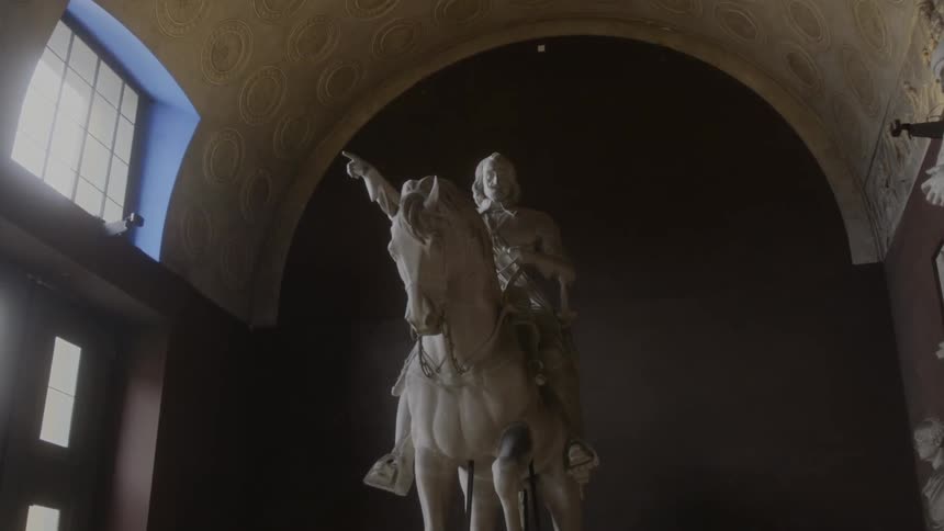 A statue of a man on a horse inside a building