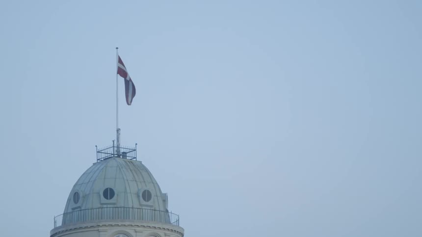 A flag on a flagpole blows in the breeze