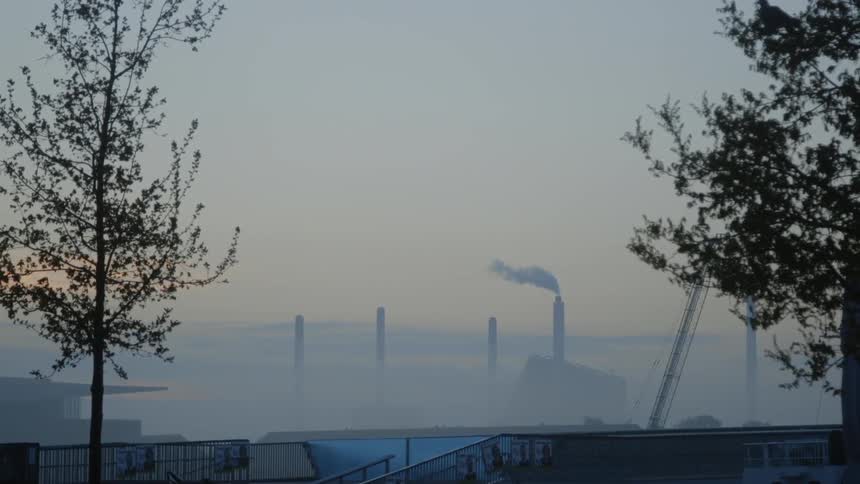 The chimney is giving off steam past the fog