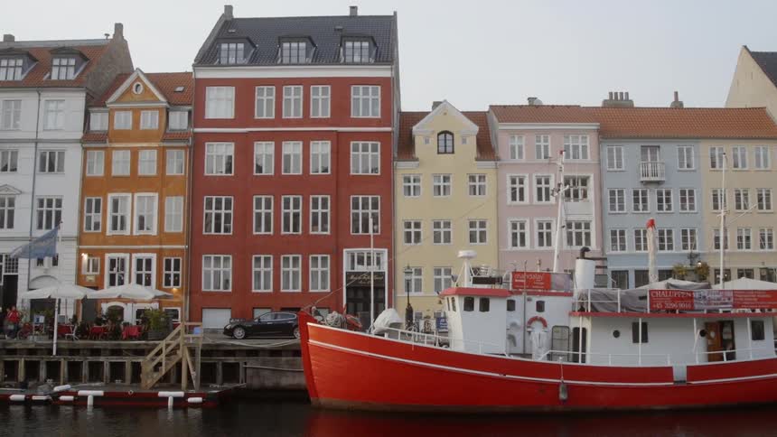 Boat floating in a canal next to a row of buildings