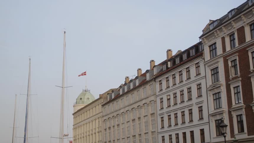 Flag atop a large building flutters in the wind