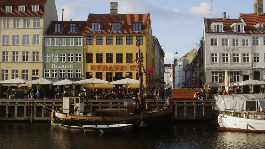 People walk along the dock of a coastal city
