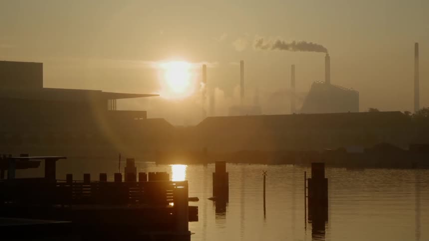 The sun is nearly sit by the buildings ahead