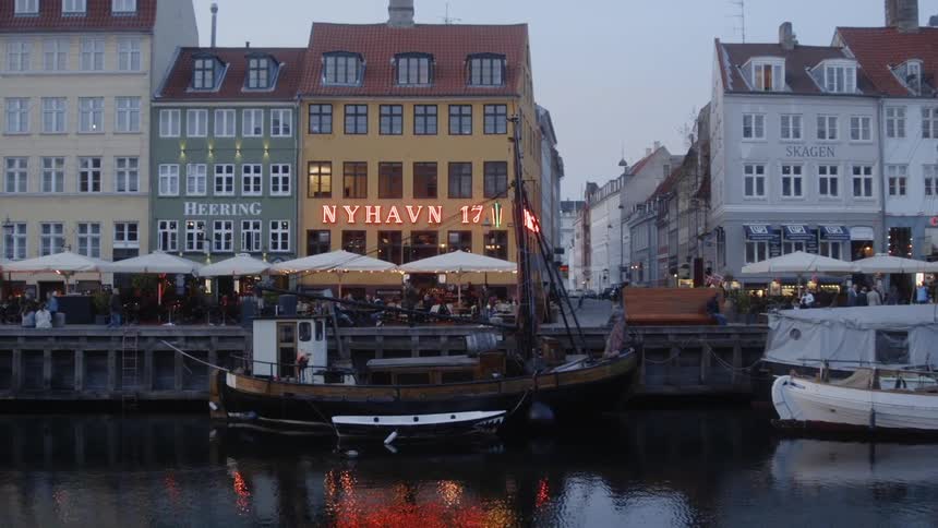 Boat floating in a canal next to a row of buildings