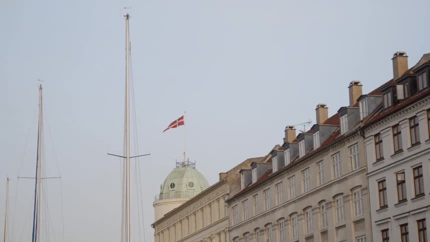 A ship floats near a city building
