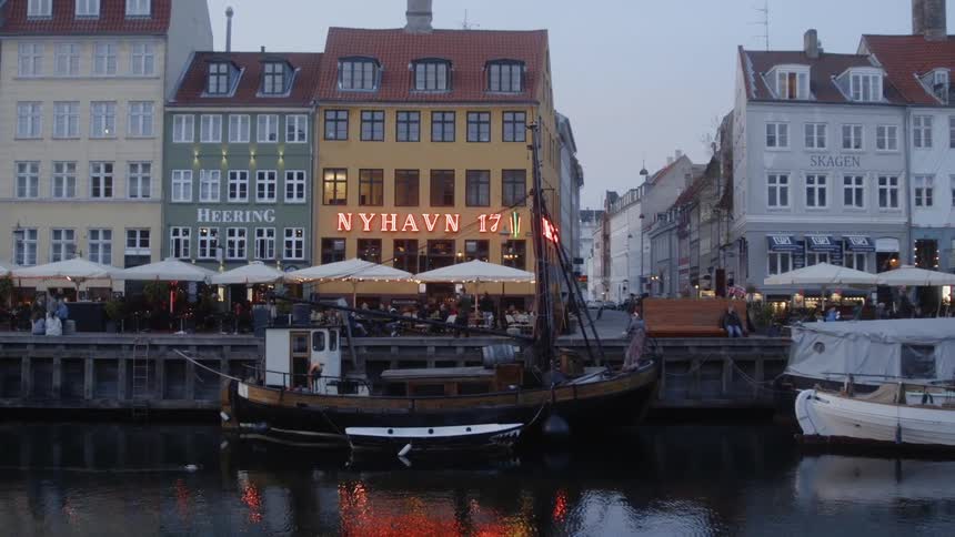 Boat floating in a canal next to a row of buildings