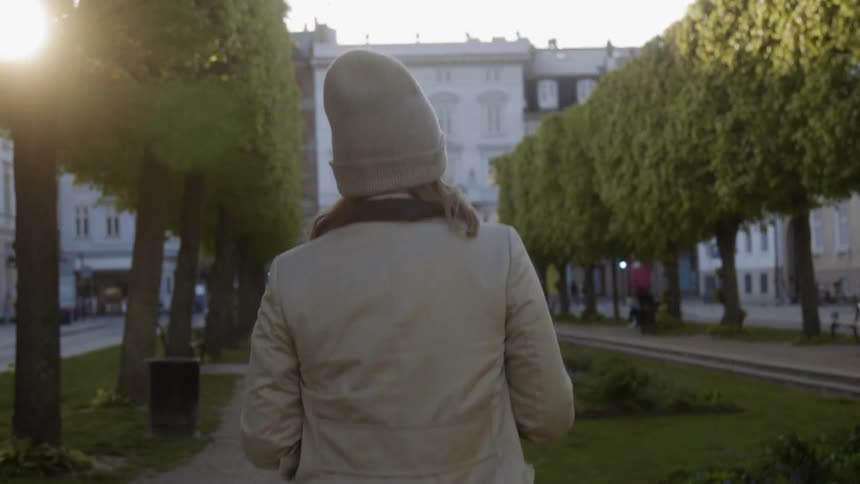 A woman on the sidewalk towards the building