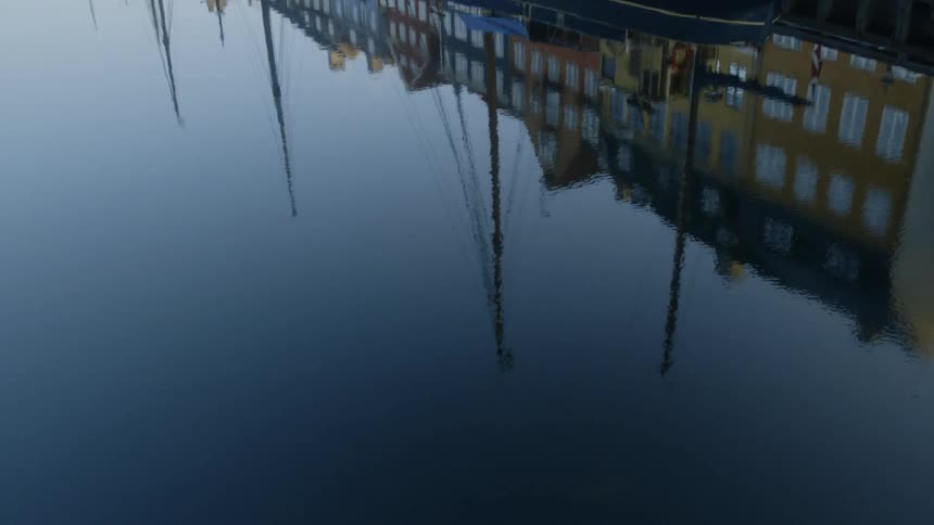 A row of buildings is reflected on the water surface