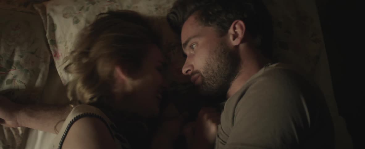 Man and woman lay down on a bed face to face