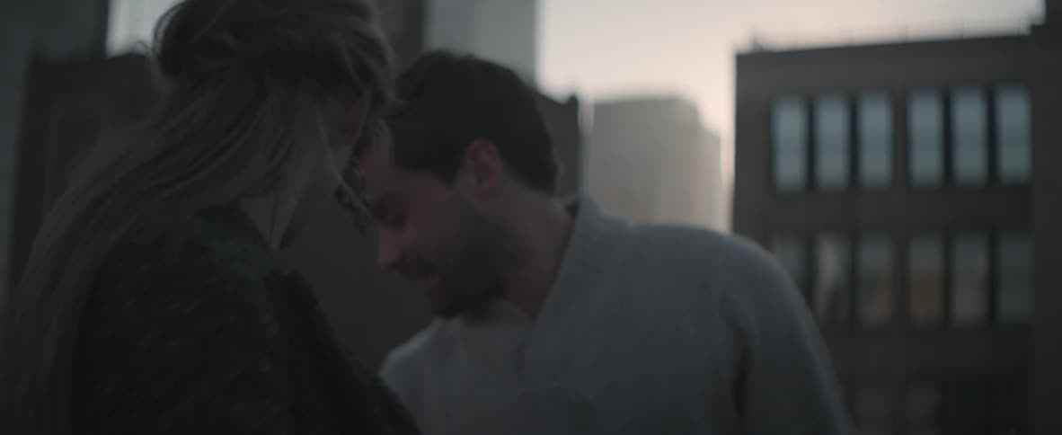 Man and woman flirting and laughing on a rooftop