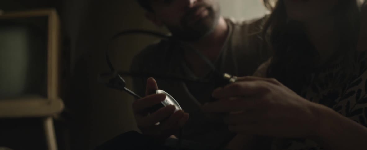 Man and woman cuddling with headphones in hand