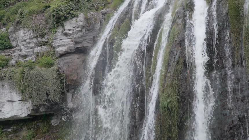 A large waterfall is pouring over the cliff