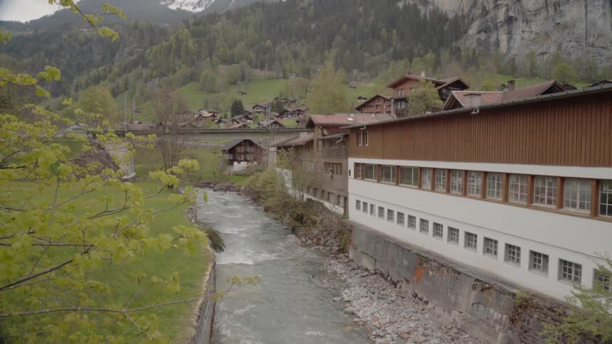 A river flows by buildings in a mountain village