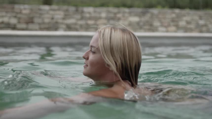 Woman swims in an outdoor pool
