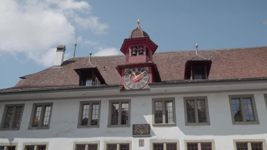 A clock hangs on a city building