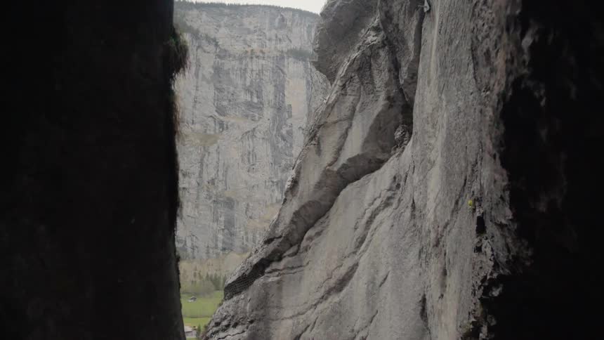 Outside of the cave are some homes near the mountain