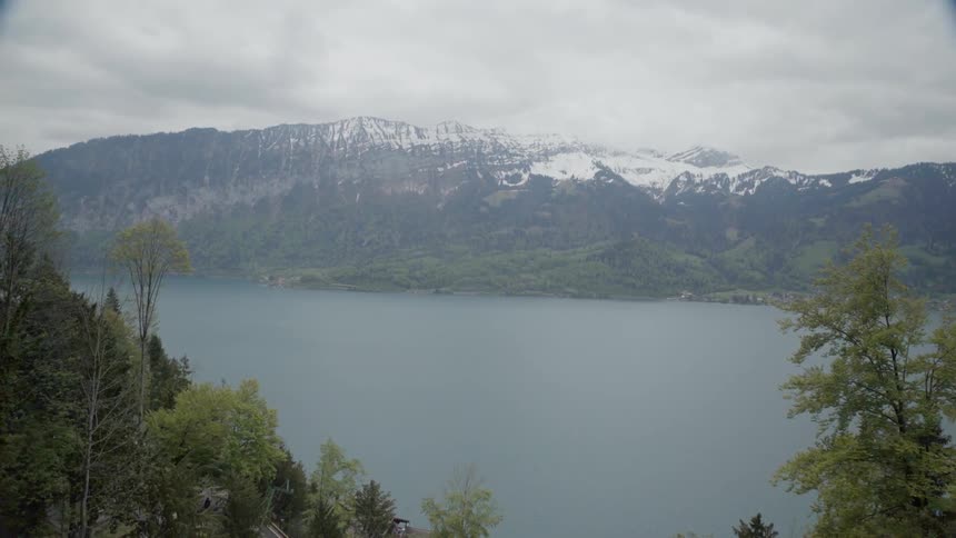 Clouds over a mountain lake and forest trees