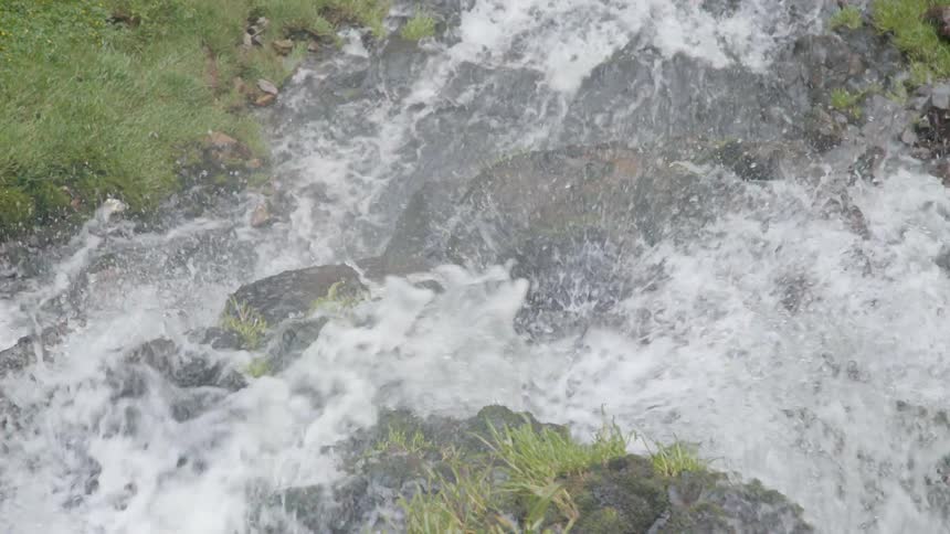The water is pouring down the stream below